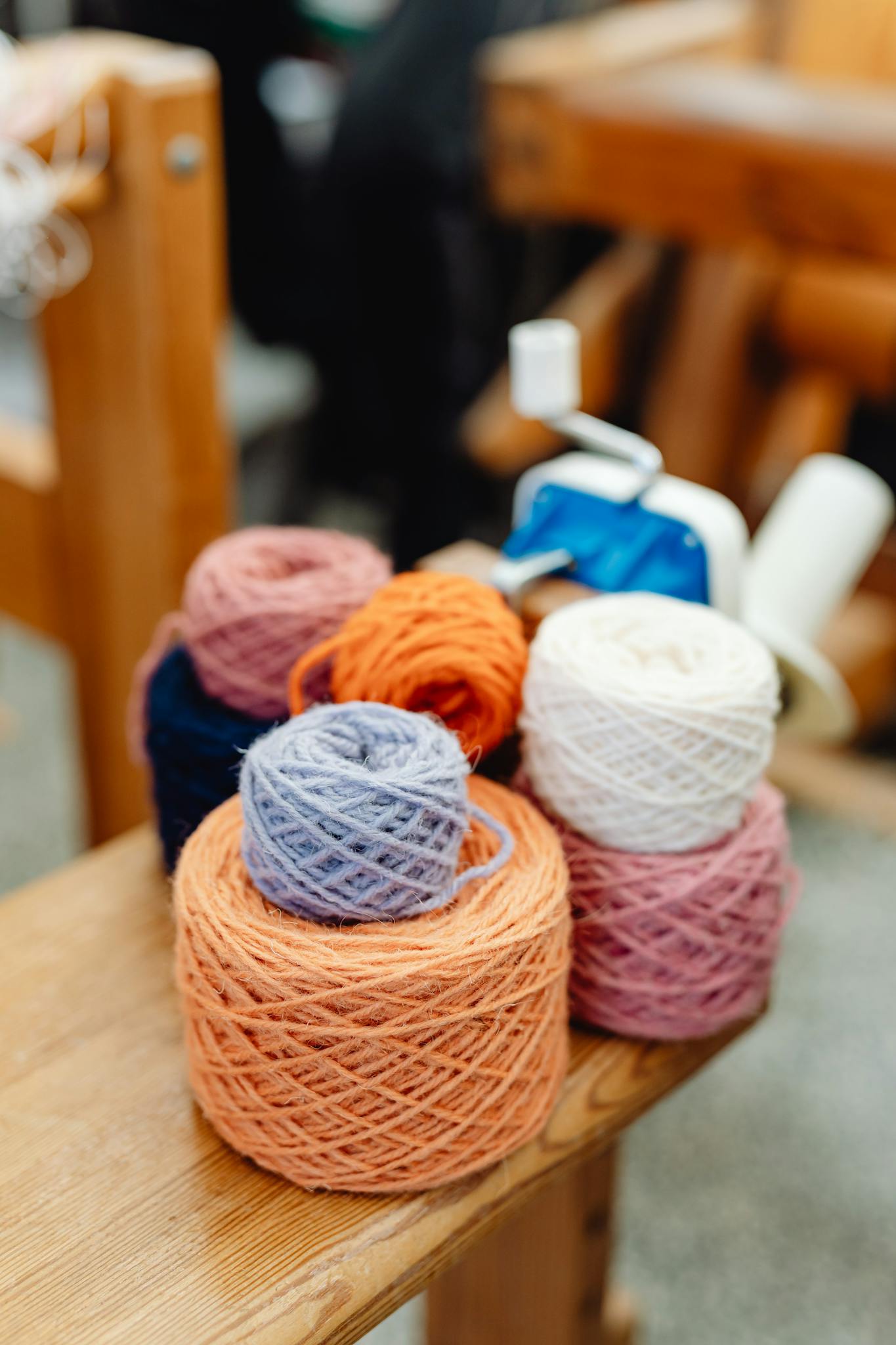 A close-up of colorful yarn balls arranged on a wooden table, perfect for crafts.